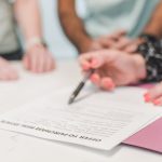 A home buyer reviewing and signing a purchase offer