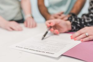 A home buyer reviewing and signing a purchase offer